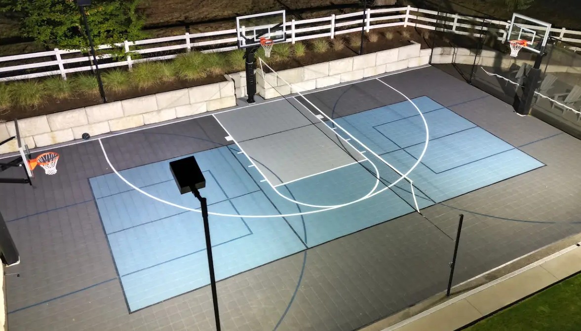 Multi-sport backyard court striped for both pickleball and basketball with net and hoop